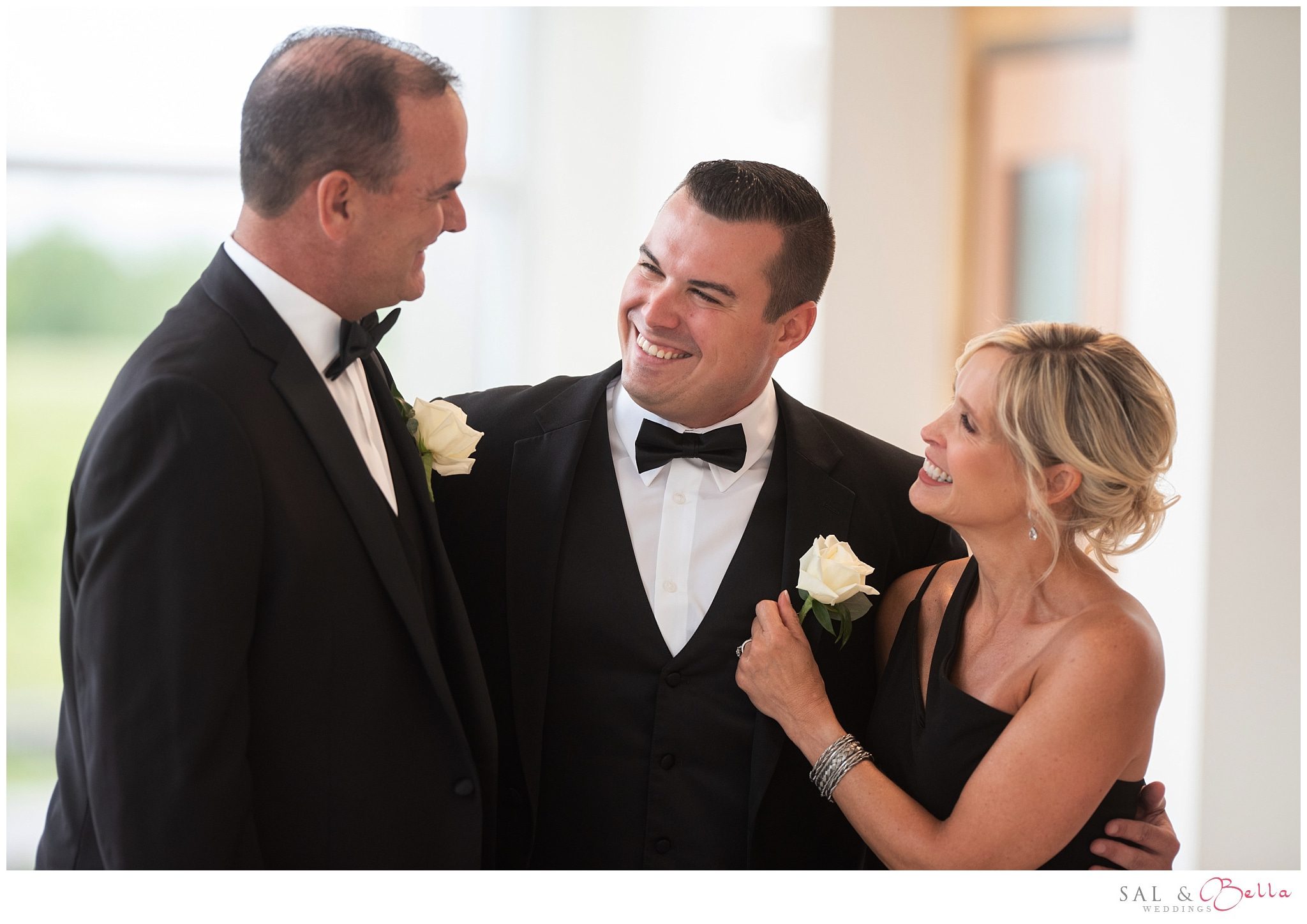 Parents of the groom hug their son for photos.