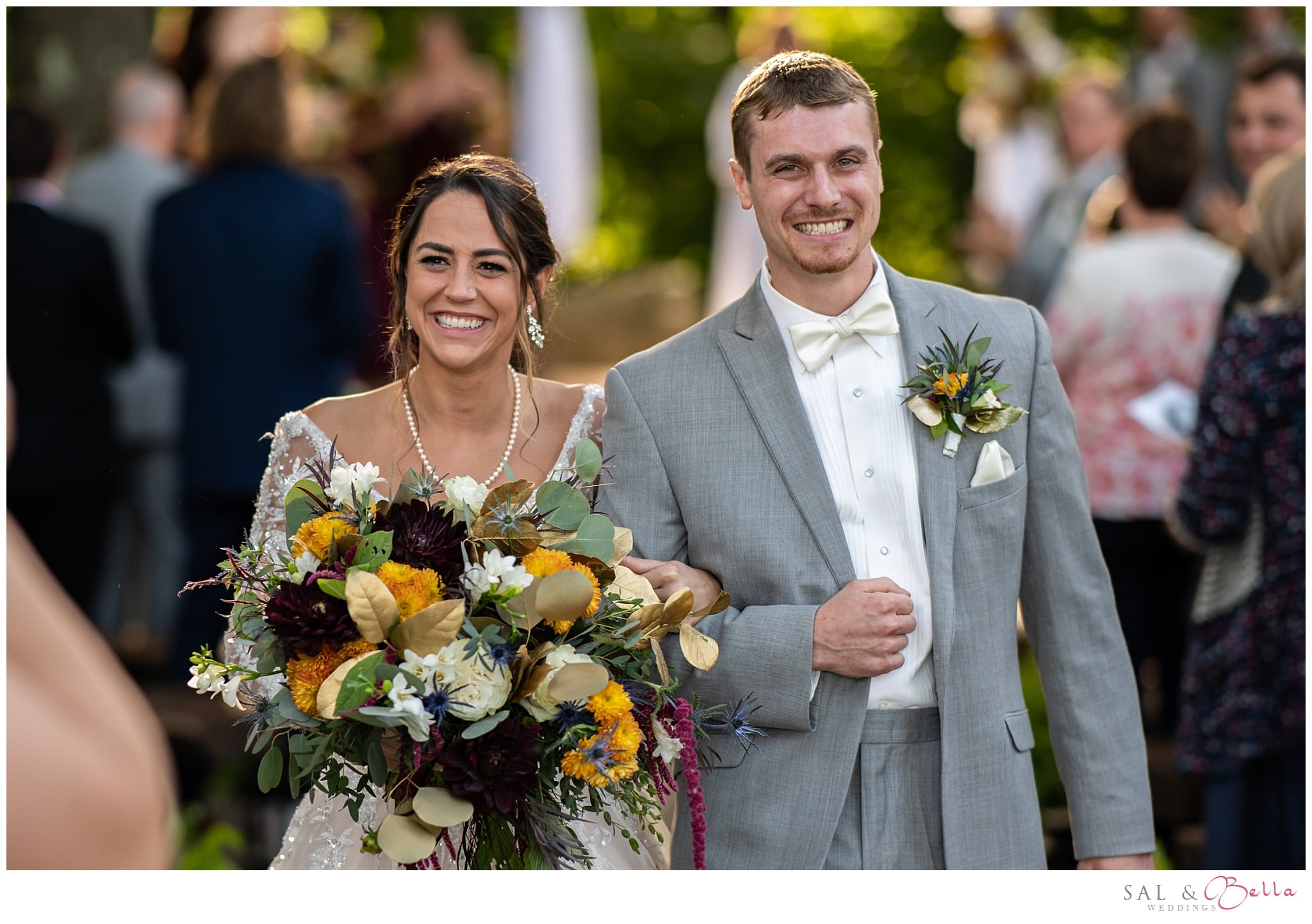Newlyweds beaming as they walk back down the aisle at Seven Springs