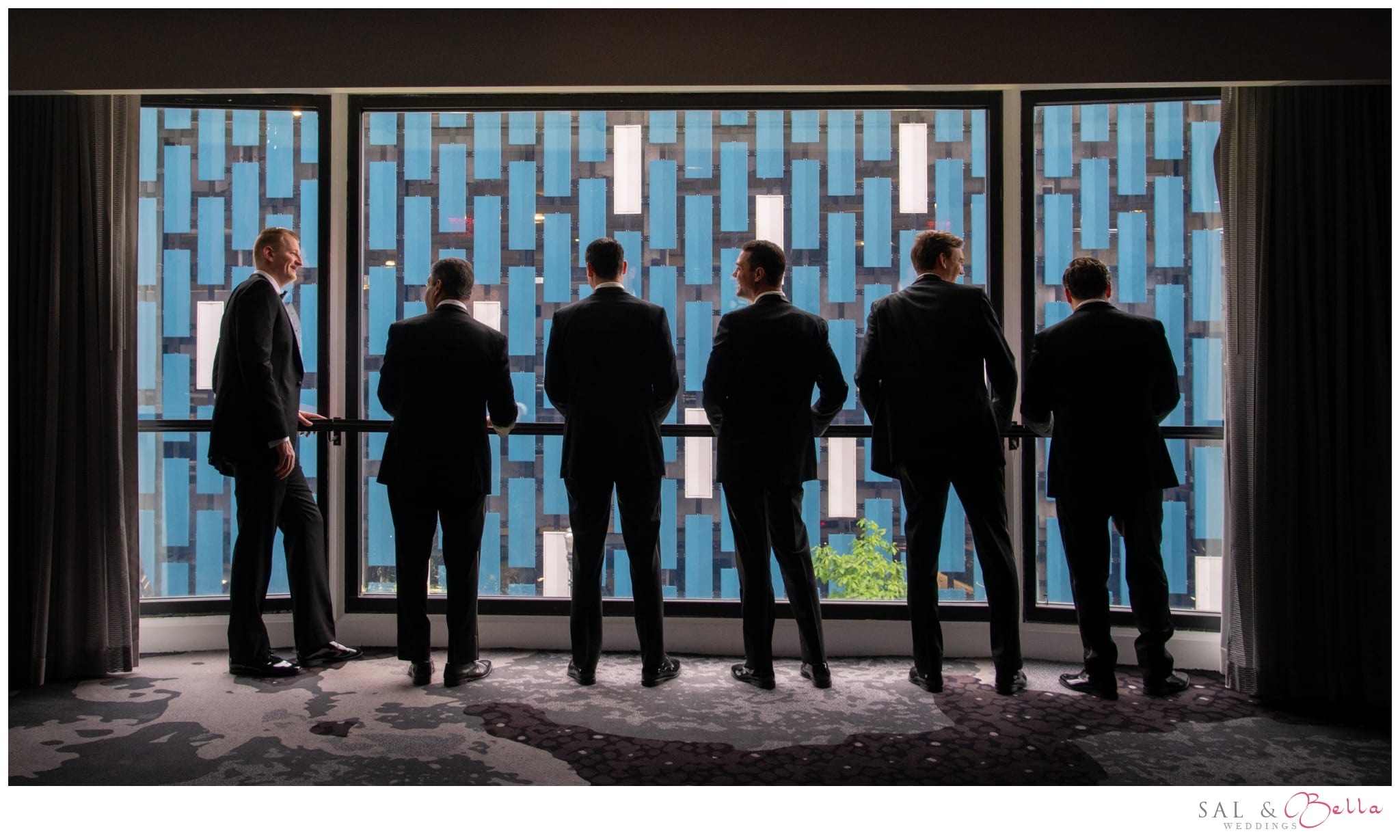 Groomsmen standing in the window at the Renaissance Hotel. 
