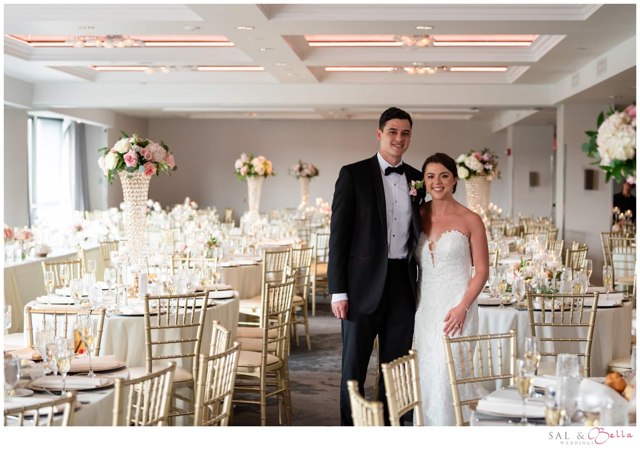 Bride and groom pose in the ballroom of the Renaissance Pittsburgh Hotel. White, pink & gold decorations. 