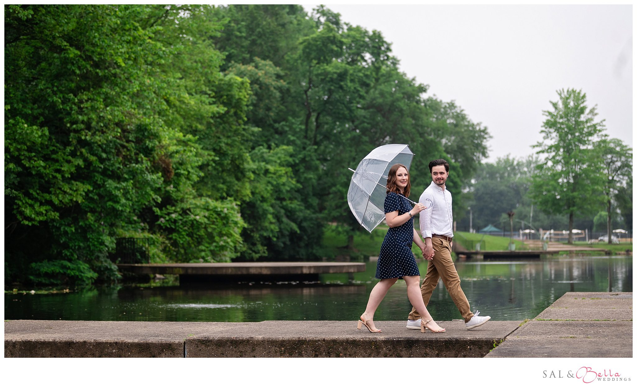 Couple walking by Carnegie Lake during foggy engagement session.