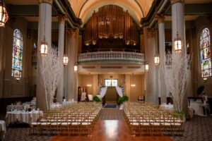 A full room view, including the original organ of a ceremony set up in the Priory's Grand Hall.