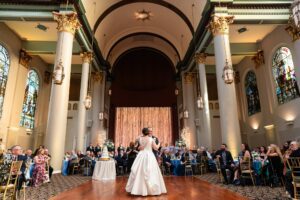 Sunlight pours into the stained glass windows of the Priory as the couple shares their first dance.