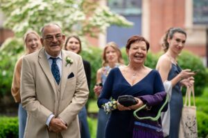 Parents smile as they watch their child share in a first look with the Priory in the background.