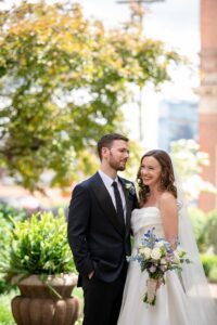 The bride and groom laugh as they pose for portraits in the summer at the priory.