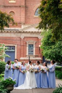 Bridesmaids posing in the garden for photos with Pittsburgh Grand Hall in the background.