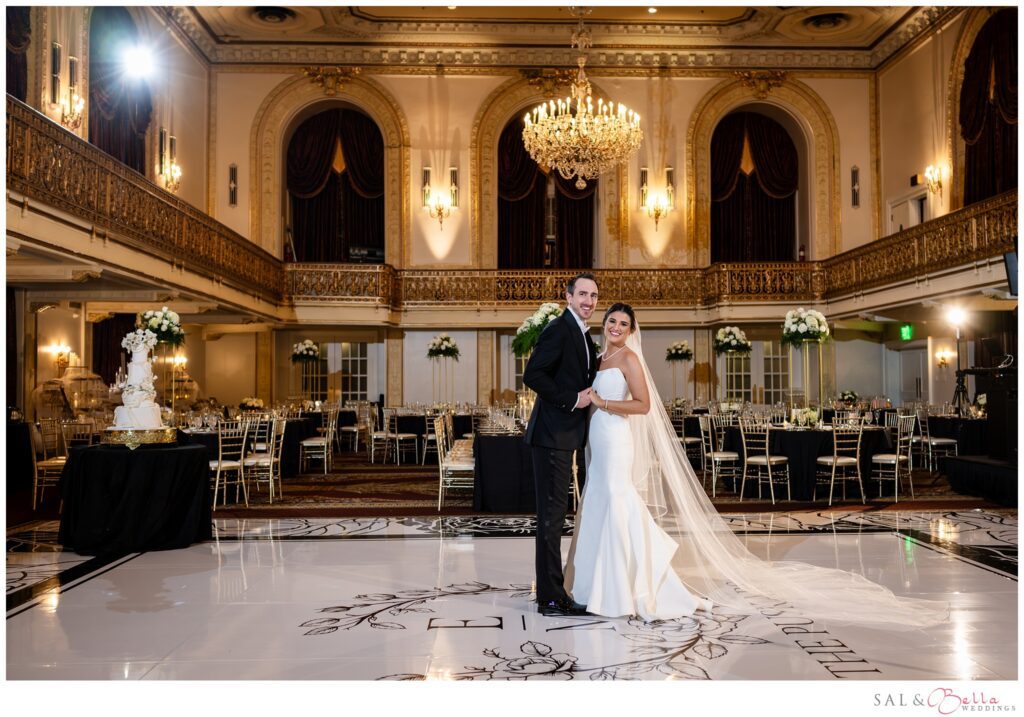 Elle and Mike posing together on their custom dance floor in the Omni William Penn Grand Ballroom