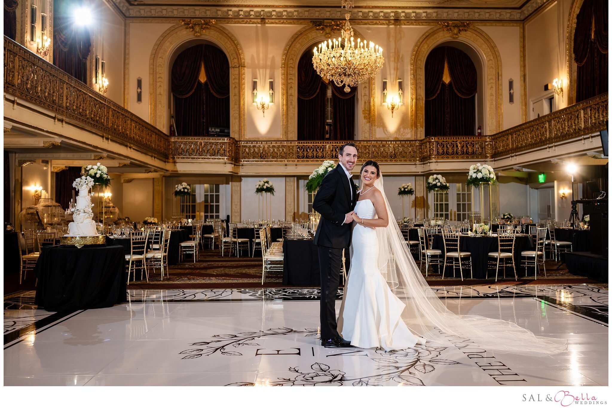 Elle and Mike posing together on their custom dance floor in the Omni William Penn Grand Ballroom