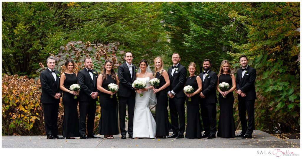 Elle and Mike with their wedding party surrounded by fall foliage at Mellon Green in Pittsburgh