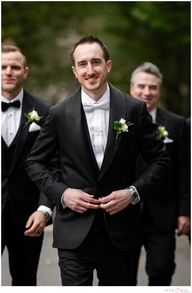 Mike posing in his black tuxedo during groomsmen portraits at Mellon Green in Pittsburgh