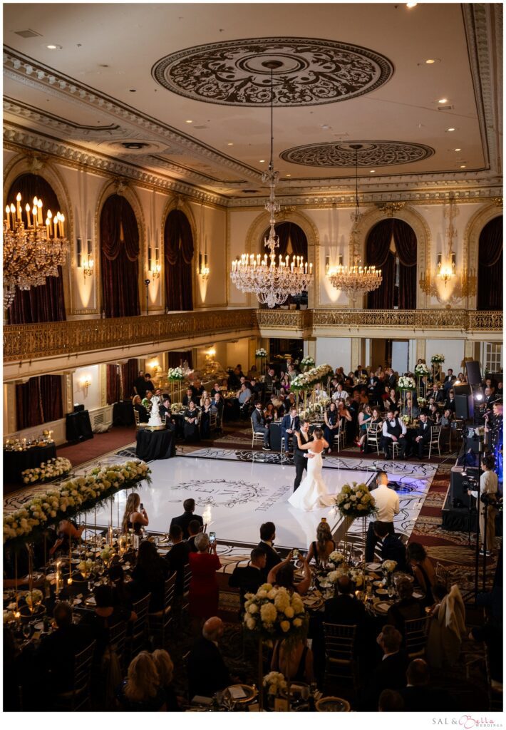 Wide view of the bride and groom's first dance surrounded by guests in the Omni William Penn Grand Ballroom